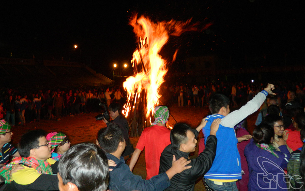 Visitors and local ethnic people exchange around camping fire